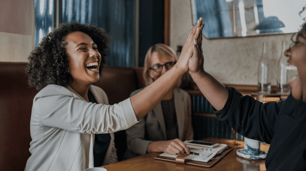 Three women in a meeting and giving a hi-five