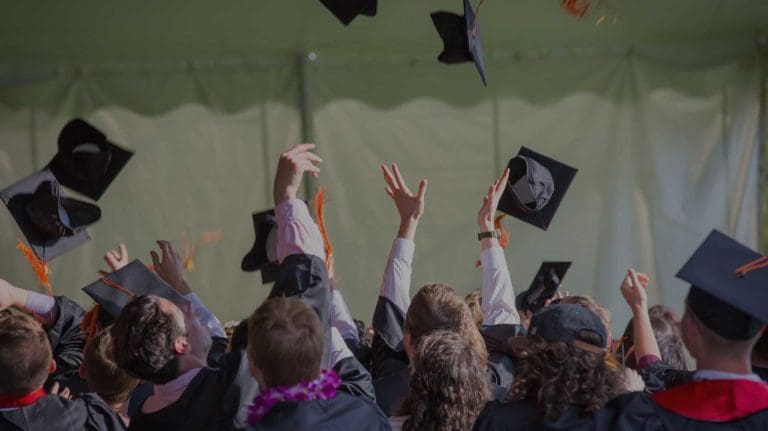 Graduates throwing motar boards in the air