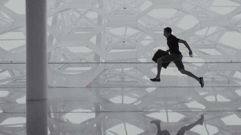 Man holding laptop bag and running