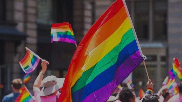 People holding pride flags in a crowd