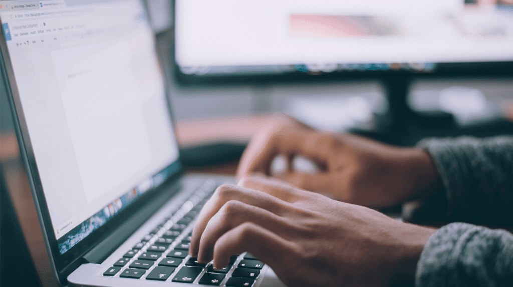 man typing on laptop